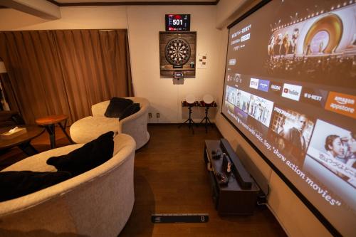 a room with two chairs and a large screen at Cinema Resorts 3 in Motobu