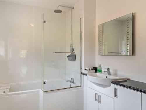 a white bathroom with a shower and a sink at 2 Bed in Launceston 52087 in Virginstow