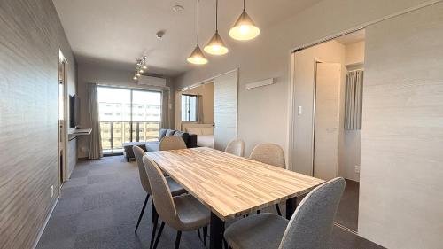 福岡市にあるLiving like hotel Hakata Premiumの木製のテーブルと椅子のあるダイニングルーム