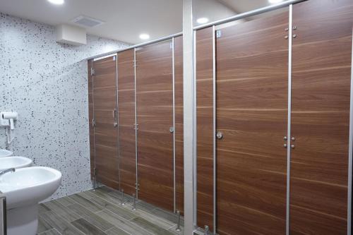 a bathroom with a shower with wooden doors at Cozy KingsizeBed เจริญนคร in Ban Hua Phrong