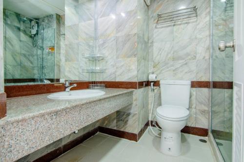 a bathroom with a toilet and a sink at โกลเด้นแลนด์รีสอร์ท in Ban Dan Kwian