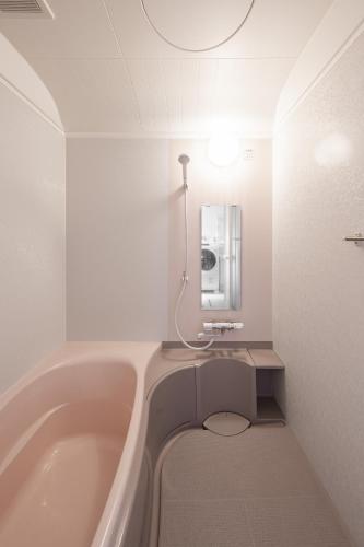 a bathroom with a bath tub and a sink at Toya Serenity Stay in Lake Toya