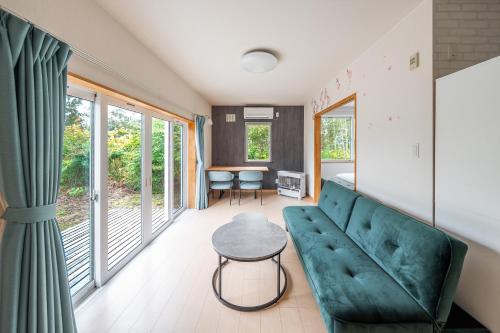 a living room with a green couch and a table at Toya Serenity Stay in Lake Toya