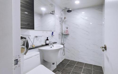 a white bathroom with a toilet and a sink at Daegu 3 rooms APT All furnished Near downtown & Dongdaegu station in Daegu