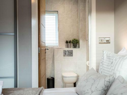 a small bathroom with a toilet and a bed at 3 Bed in Westward Ho 60264 in Westward Ho