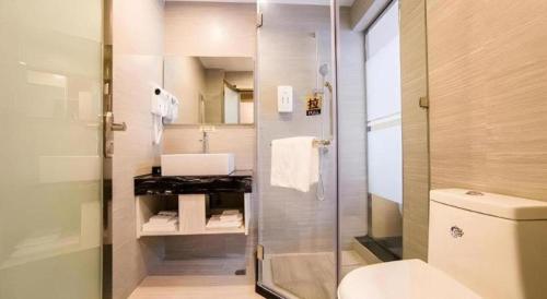 een badkamer met douche, wastafel en toilet bij JTOUR Inn Zhuhai Xiangzhou Mingzhu Light Rail Station in Zhuhai