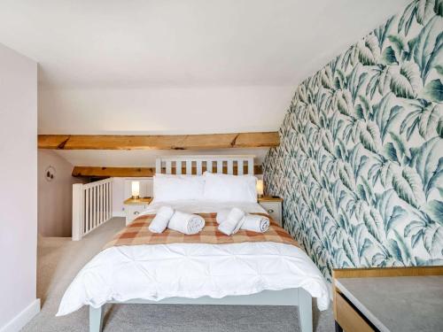 a bedroom with a white bed with a wall mural at 3 Bed in Newby Bridge 87960 in Greenodd