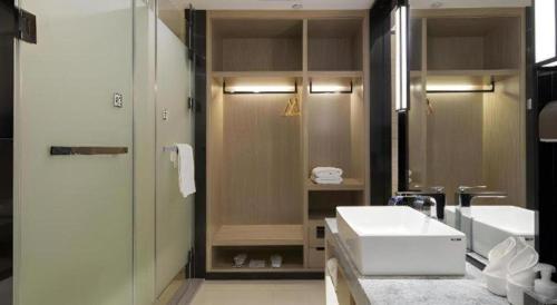 a bathroom with a white sink and a shower at Echarm Hotel Changsha Gaoqiao in Changsha