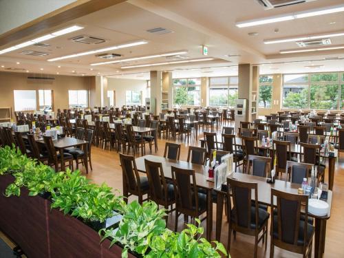 a large banquet hall with tables and chairs at Kur and Hotel Isawa in Fuefuki