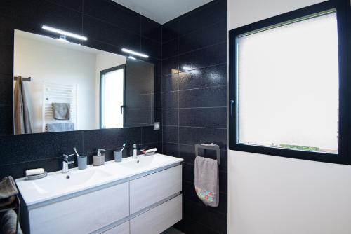 a bathroom with a white sink and a mirror at Entre genêts et chardons in Banassac