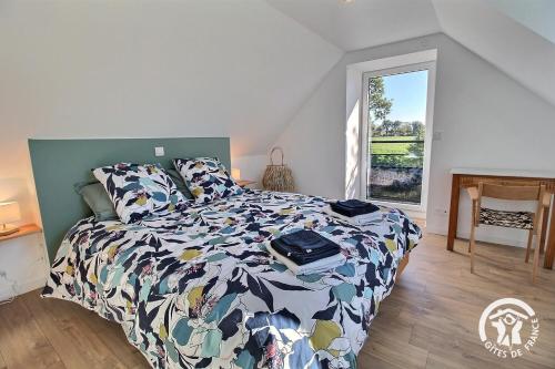 een slaapkamer met een bed met een bloemrijk dekbed bij Rumedon in Ploumilliau