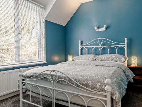 a blue bedroom with a bed with a blue wall at 2 Bed in Bovey Tracey PRIMC in Hennock