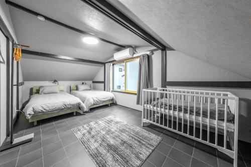 a bedroom with two beds and a crib at Akatsuki in Kami-furano