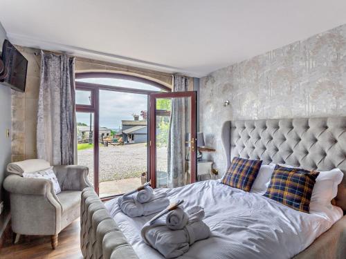 a bedroom with a bed and a couch and a window at 8 Bed in Pateley Bridge 95111 in Sawley