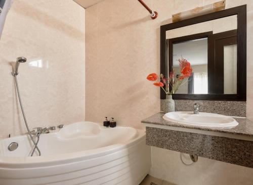 a bathroom with a tub and a sink and a mirror at Asian Ruby Hotel & Spa - 122F Bui Thi Xuân Street in Ho Chi Minh City