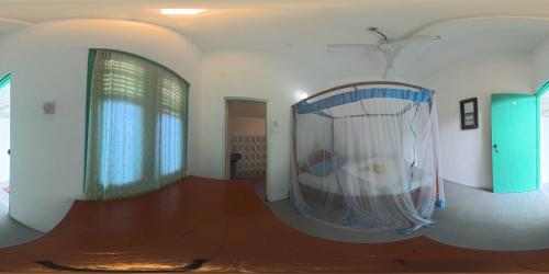 a room with a room with a bed and a window at Asanka Surf House & Restaurant with pool in Midigama