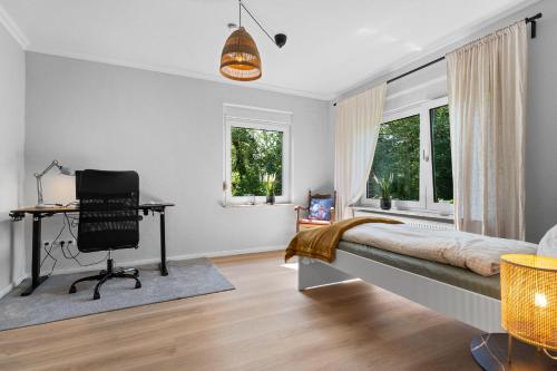 a bedroom with a bed and a desk and a chair at Villa Wilma Hinte in Suurhusen