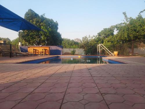 a swimming pool with an umbrella and a water slide at Buffalo Bob Lodge in Livingstone