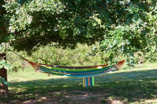 a colorful hammock in a field under a tree at Casetta delle rose in Bormida