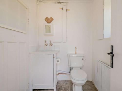 Un baño blanco con inodoro y lavabo. en 4 Bed in Isle of Purbeck IC036, en Worth Matravers