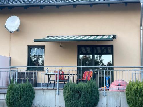 滨湖克拉科Doppelferienhaus am See & Wald的阳台上配有桌椅的露台