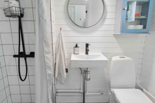a white bathroom with a sink and a mirror at Cosy Summerhouse With Private Garden in Nyrup