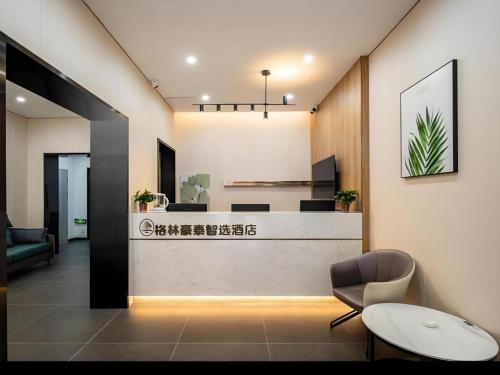 a lobby with a reception desk and a chair at Green Tree Inn Shenyang Middle Street in Shenyang