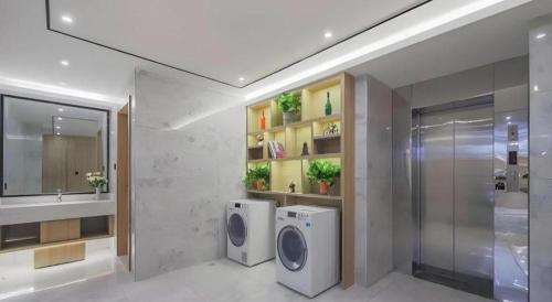 南京市にあるGreen Tree Inn Nanjing Xinjiekou Wangfu Avenueのバスルーム(洗濯機2台、シンク付)