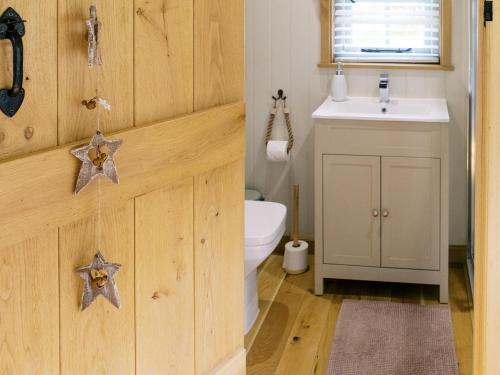 a bathroom with a toilet and a sink at Herbie's Shepherds Hut at Shepherds Lodge Retreat and Wellness in Nottingham