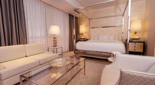 Una habitación de hotel con una cama, un sofá y una mesa. en Ahern Hotel and Event Center, en Las Vegas