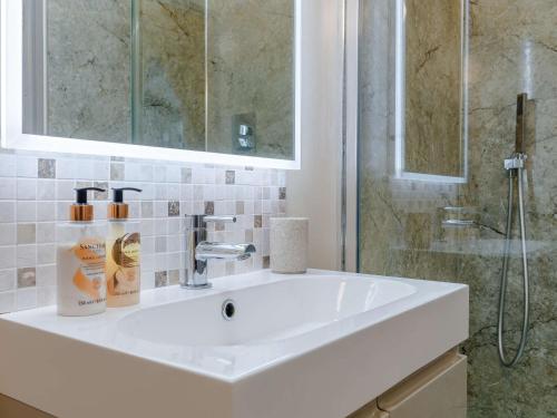 ein Badezimmer mit einem weißen Waschbecken und einer Dusche in der Unterkunft 1 Bed in Cheltenham 60276 in Tirley