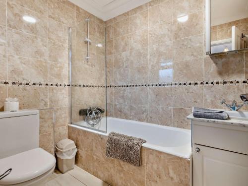 a bathroom with a tub and a toilet and a sink at 2 Bed in Bacton 75391 in Bacton