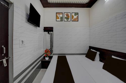 a room with a bed and a tv on a wall at Super Hotel O Krishna Janam Bhoomi Formerly Ashirwad Palace in Mathura