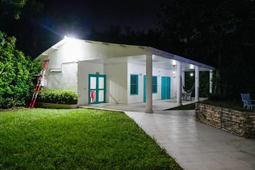 a small white building with blue doors at night at Casa Hotel Villa Sabrosura in Mariquita