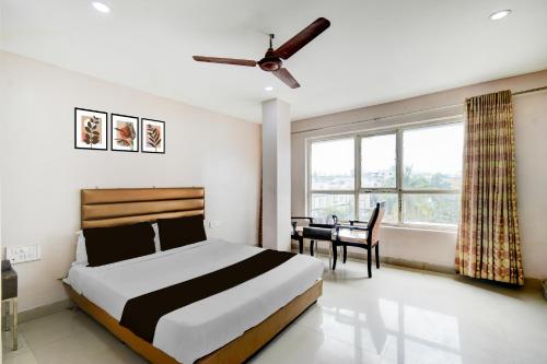 a bedroom with a bed and a desk in it at Super Townhouse Narayanaguda Metro Station Formerly Hotel Anshu Grand in Vidya Nagar