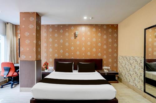 a bedroom with a large bed and a desk at Super Townhouse Oak ONGC Crossway Formerly Hotel Gold Stone Comfort in Dehradun