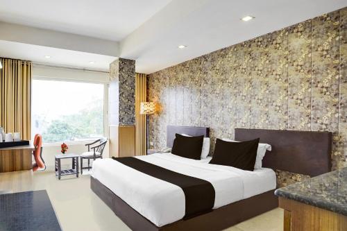 デヘラードゥーンにあるSuper Townhouse Oak ONGC Crossway Formerly Hotel Gold Stone Comfortの部屋の中に大きなベッドがある寝室