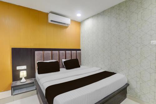 ゴーラクプルにあるSuper Hotel O Medical College Basaratpur Gorakhpurの白と黄色の壁の大きなベッドのある寝室