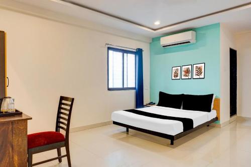 a bedroom with a bed and a chair at Super Collection O Manjari - Mundhwa Road Formerly 7 Treats in Mundhwa