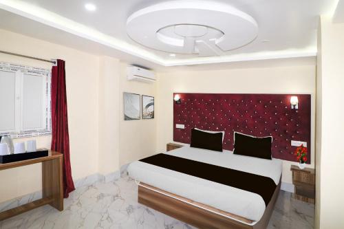 a bedroom with a large bed with a red headboard at Super Townhouse Bank More Dhanbad Formerly Rise And Dine in Dhanbād