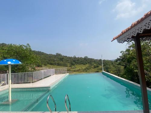 une piscine avec vue sur les montagnes dans l'établissement Eshi Resorts and Restaurant - Bhimashankars Jungle Luxury Resort, à Taleghar