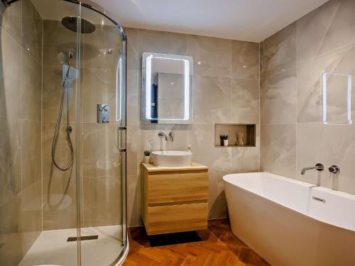 a bathroom with a tub and a sink and a shower at 4 Bed in Westward Ho 86640 in Bideford