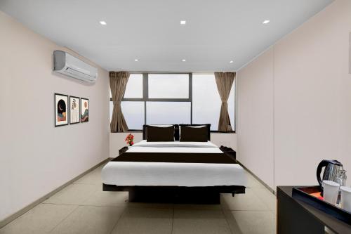 ChākanにあるSuper Townhouse Chakan MIDC Pune Formerly Renuka Executiveの大きなベッドと窓のある寝室