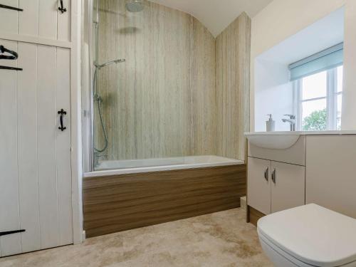a bathroom with a tub and a toilet and a shower at 4 Bed in Betws y coed 52111 in Capel Garmon