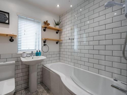 a white bathroom with a tub and a sink at 2 Bed in Anstruther 66733 in Pittenweem