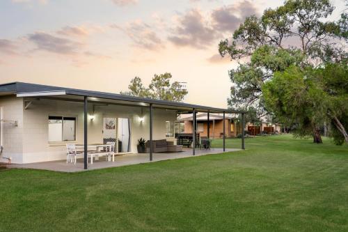 a house with a large patio and a yard at Riversands Rest Accommodation Scenic Riverfront Cottages, Paringa in Renmark