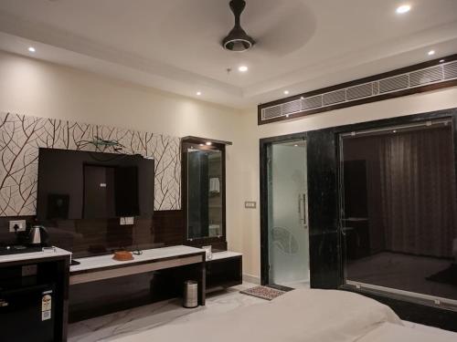 La salle de bains est pourvue d'une douche, d'un lavabo et d'une télévision. dans l'établissement Resort K Sea View Mandarmoni, à Mandarmoni