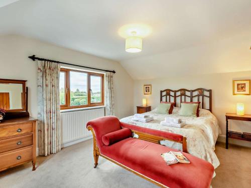 Whitfordにある3 Bed in Holywell 89614のベッドと赤い椅子のある寝室