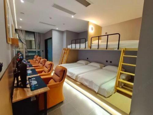 a bedroom with two bunk beds and a desk and chairs at Shenzhen Nan Fei Yuan Hotel in Shenzhen
