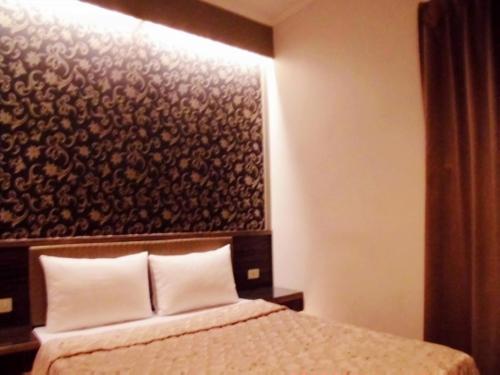a bedroom with a bed with a large headboard at Baseball Hotel in Hsinchu City